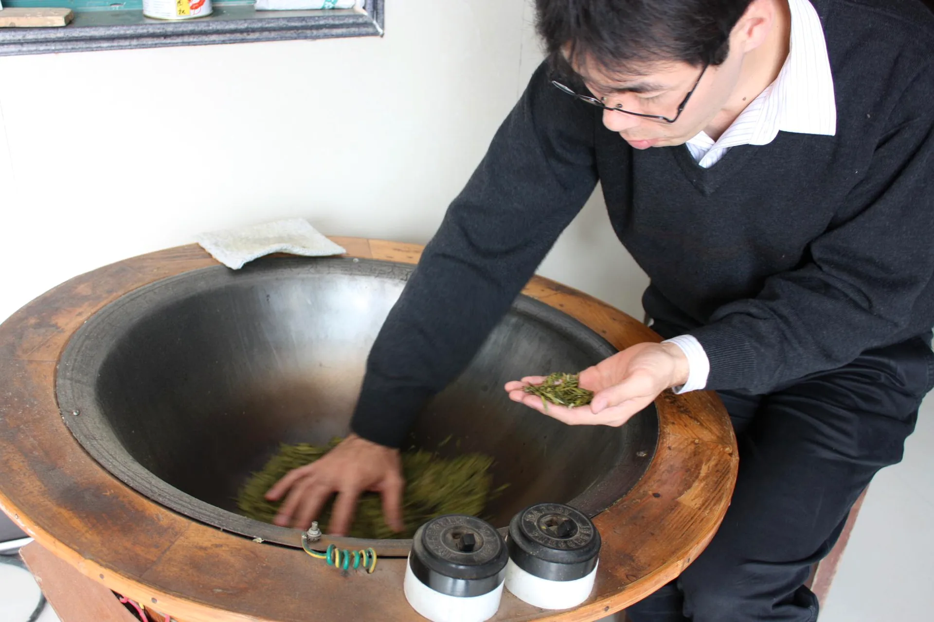 製茶用の鍋で茶葉を扱い熱の変化を確かめる大高勇気